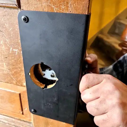 A black door wrap added to an old door to help reinforce it