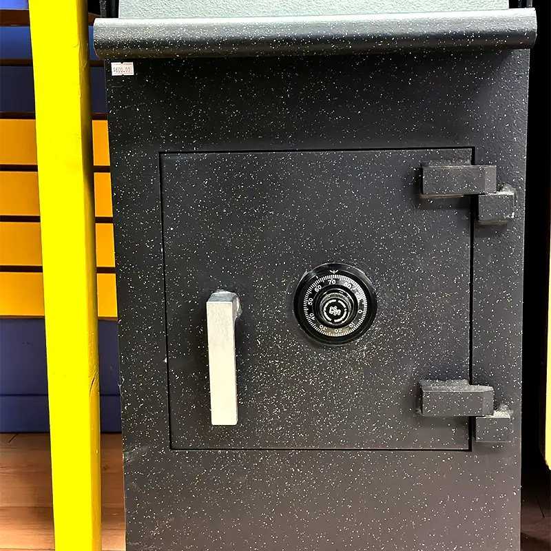 A small great safe with a silver handle and a black dial in the centre