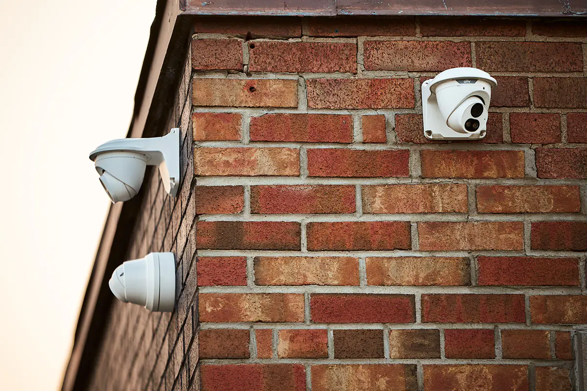 Three security cameras installed on a brick building