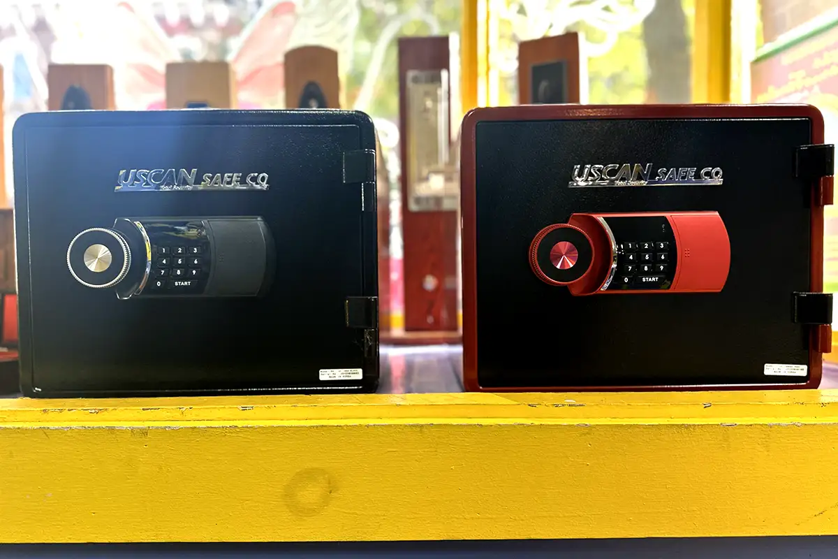 Two Uscan safes on a yellow table with a bright window behind them